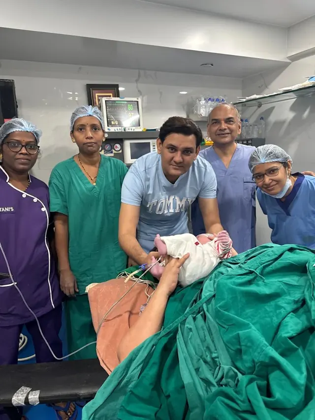Dr. Patani and the delivery team with a newborn and the new father in the operation theatre