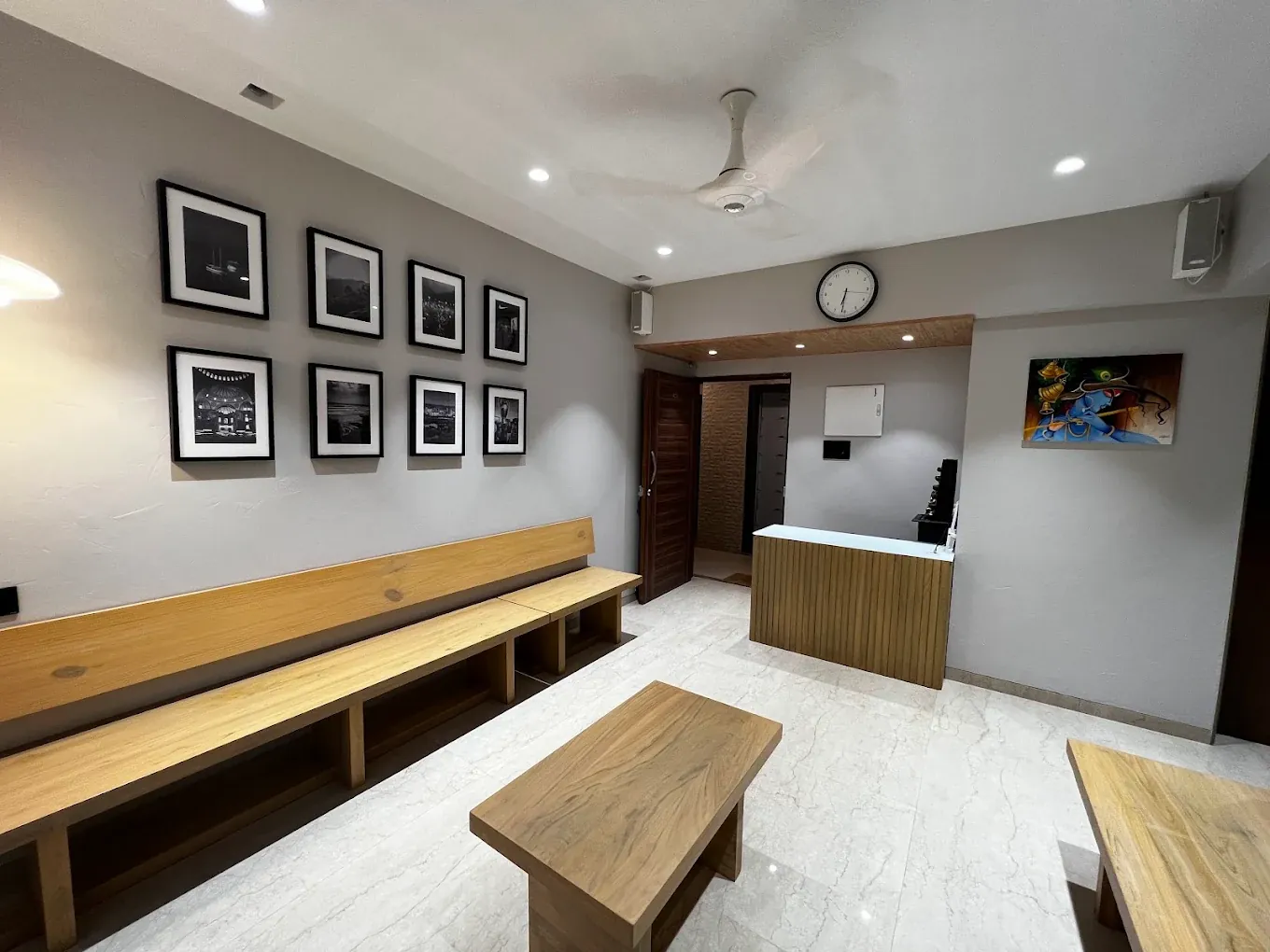 Reception desk and waiting area with framed photographs and wooden benches